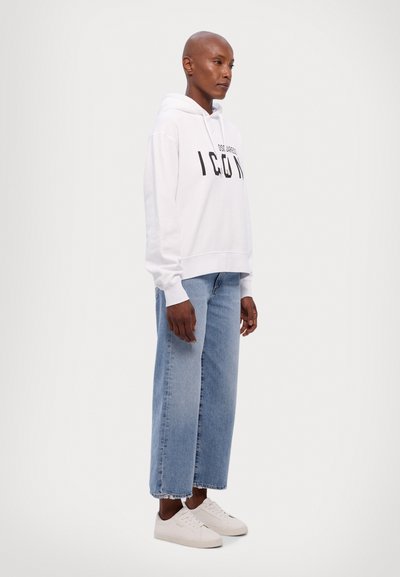 White hooded sweatshirt with "ICON" in black letters, paired with light blue wide-leg jeans and white sneakers. Smooth fabric and casual fit.
