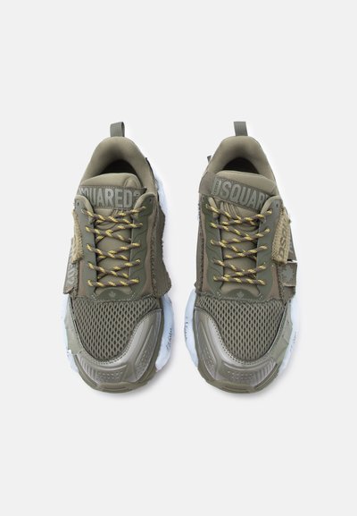 Paire de baskets en mesh et tissu vert olive avec des lacets soulignés de jaune, marquage DSQUARED2 sur les languettes, et semelles blanches à motifs.