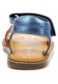 Sandalo in pelle blu navy con strap in Velcro, soletta color tan con motivi floreali bianchi e suola in gomma marrone per una buona aderenza.