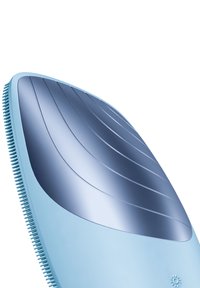 Brosse à cheveux bleu clair avec un dessus lisse et courbé, présentant des stries, et un manche texturé avec de petites soies sur les côtés.
