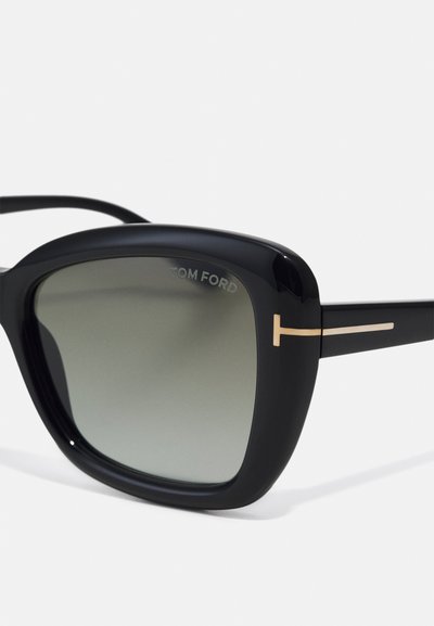 Černé plastové sluneční brýle se šedými gradientními skly, zdobené zlatými kovovými detaily a obdélníkovým rámem. Viditelné logo "TOM FORD".