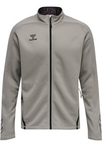 Chaqueta gris con cierre de cremallera, hecha de un tejido suave. Presenta un cuello tipo stand-up, cremallera negra y un logo en el lado izquierdo del pecho. Incluye bolsillos laterales.