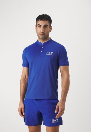 Blue short-sleeve polo shirt featuring a collared neckline, three-button placket, and EA7 logo on the chest. Smooth, athletic fit.