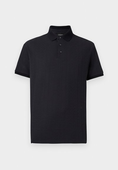 Črna polo majica z teksturiranim vzorcem, z zaponko s tremi gumbi in klasičnim ovratnikom. Kratki rokavi in raven spodnji rob. Mehka tkanina.