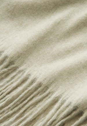 Soft beige wool fabric with fringe detailing along one edge, highlighting texture and fibers.