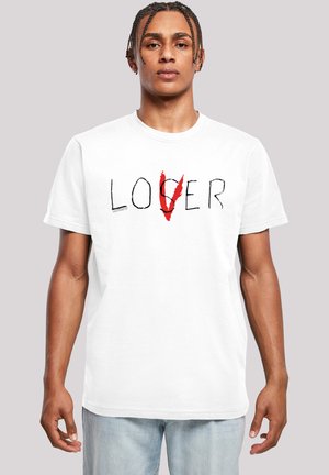 White cotton t-shirt featuring the word "LOVER" with a red "V" and black accents. Short sleeves, crew neck, relaxed fit.