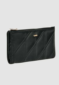 Portafoglio nero in pelle trapuntata con chiusura a zip, caratterizzato da cuciture diagonali e un piccolo logo dorato. Texture liscia, forma rettangolare.