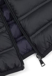 Czarna kurtka puchowa z dwukierunkowym zamkiem błyskawicznym, z pikowanym wzorem i miękką granatową podszewką. Tkanina ma gładką, błyszczącą fakturę.