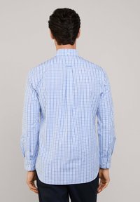 Camicia a quadratini azzurri, maniche lunghe, colletto a bottoni, piega sul retro e orlo arrotondato, realizzata in un morbido misto cotone.