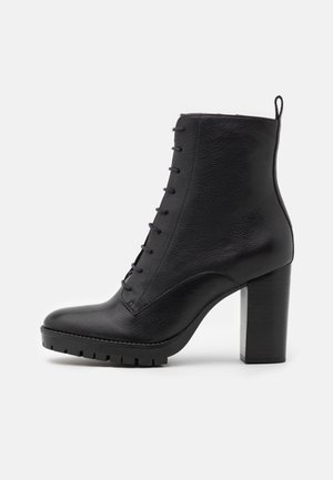 Bottes chevilles en cuir noir avec un talon bloc haut, un laçage à l'avant et une finition texturée ; dotées d'une semelle robuste pour une meilleure accroche.