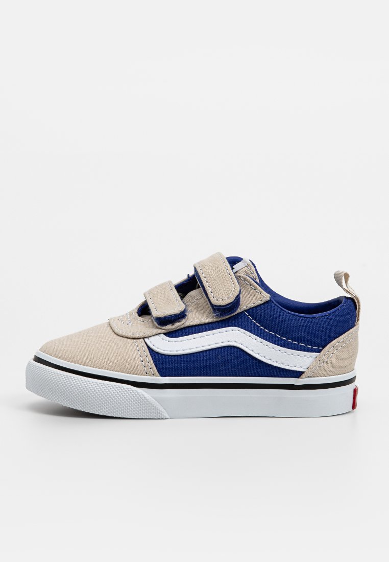 Blå och beige canvas sneakers med kardborreband, vit söm och svart gummisula. Har en vit sidrand och röda accenter.