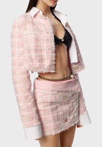 Rosa Tweed-Jacke mit Fransenverzierung, weißem Kragen, kombiniert mit einem passenden rosa Tweed-Rock, der über goldene Hardware und ein enges Design verfügt.