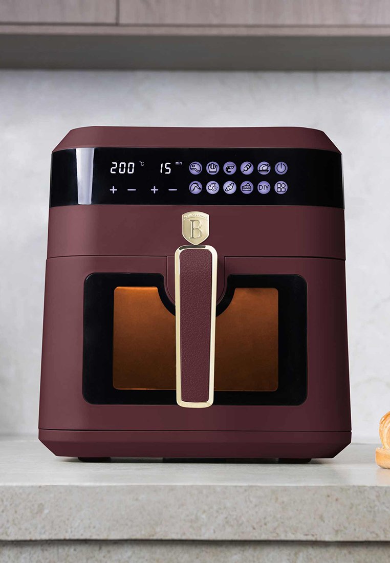 Bordeaux heteluchtfriteuse met een glanzend zwart bedieningspaneel, digitaal display, gouden accenten en een doorzichtige venster dat het kookcompartiment toont.