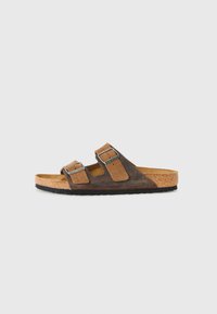 Brown leather and suede sandal with two adjustable metal buckle straps and cork sole with black rubber bottom, side view.