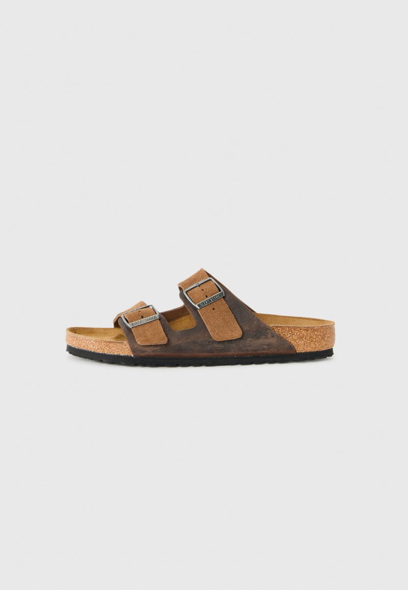 Brown leather and suede sandal with two adjustable metal buckle straps and cork sole with black rubber bottom, side view.