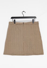 Brun mönstrad kjol med rak form, med en texturerad rutdesign och en dragkedja i ryggen. Hänger från en svart plastkrok.