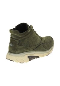 Grüner Wildleder-Ankle-Boot mit runder Spitze, gepolstertem Schaft und dicker cremefarbener Sohle. Merkmale dezente Nähte und ein Markenakzent an der Ferse.