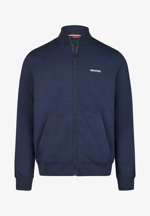 Veste zippée bleu marine en tissu doux, dotée d'un col haut, de deux poches avant et d'un logo blanc sur la poitrine gauche.