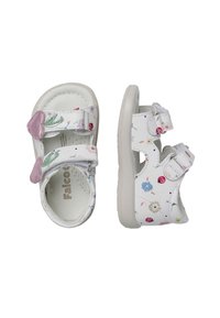 Witte kindersandalen met bloemmotieven, twee verstelbare bandjes, roze accenten en een gestructureerde zool. Kenmerkt een gevoerde binnenkant voor comfort.