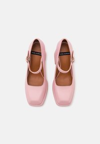 Roze leren schoenen met een vierkante neus, enkelbandje en blokhak. Gladde textuur en minimalistisch design met een beige binnenvoering.