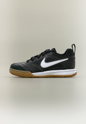 Sort-hvid Nike sportssko med gummisål, snørelukning, øvre del i mesh og syntetisk materiale samt trækflap på hælen.