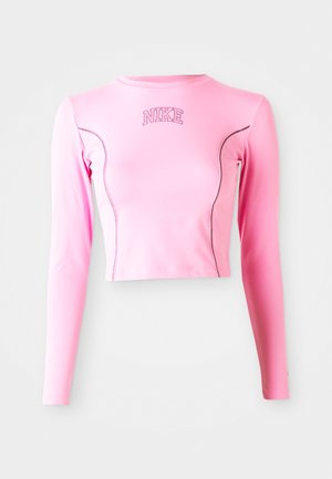 Różowy crop top z długim rękawem, wykonany z elastycznego materiału. Posiada okrągły dekolt i kontrastowe przeszycia. Logo Nike jest wyszyte na klatce piersiowej.