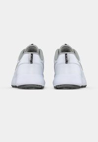 White sneakers with grey accents, smooth synthetic upper, rounded shape, and black outsole. Features a small tab with brand text on the back.