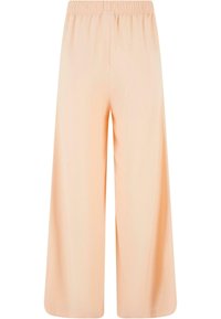 Pantalon à jambes larges et taille haute de couleur pêche clair avec ceinture élastique, fabriqué en tissu doux et fluide, conçu pour un confort décontracté.
