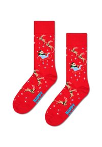 Czerwone skarpetki z wesołym wzorem reniferów i Świętego Mikołaja w saniach, z niebieskimi i białymi akcentami oraz wzorami gwiazd. Tekst: "SZCZĘŚLIWE".