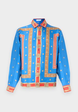 Niebieska koszula z długim rękawem z wzorami czerwonych i złotych łańcuchów oraz medalików, zapinana na guziki z szpiczastym kołnierzem.