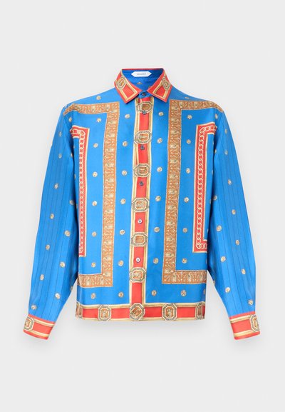 Modrá košeľa s dlhým rukávom so vzormi červených a zlatých reťazí a medailónov, zapínanie na gombíky vpredu a špicatým golierom.