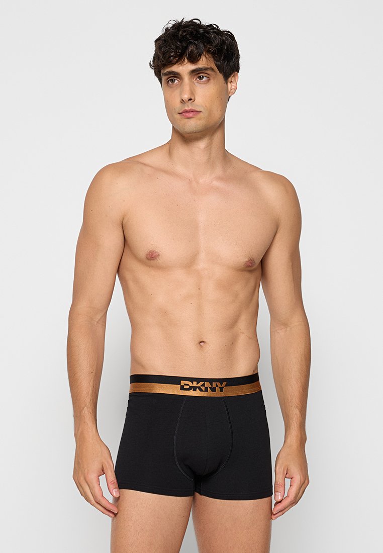 Schwarze Baumwollboxershorts mit einem kontrastierenden goldenen DKNY-Logo auf dem elastischen Taillenbund; minimalistisches Design, eng anliegende Form.