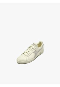 Sneaker bianco in pelle con punta perforata, accentuato in suede grigio, lacci piatti e suola texturizzata. Presenta un logo sulla linguetta.