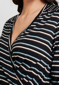 Czarna bluzka z materiału z poziomymi paskami w jasnoniebieskim, białym i złotym kolorze. Posiada głęboki dekolt w serek i miękką fakturę.