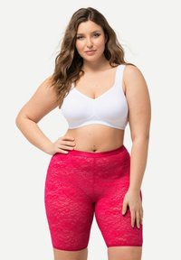 Witte, zachte stoffen bralette gecombineerd met felroze kanten shorts met een bloemmotief en een elastische tailleband.