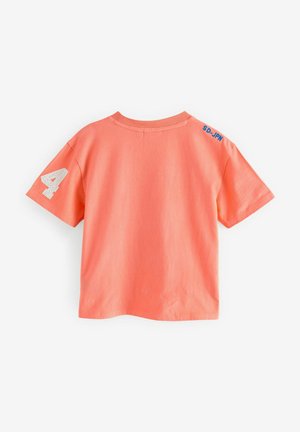 Korallfärgad t-shirt med korta ärmar som har ett strukturerat vitt nummer "4" på vänster ärm och blå "SD-JPN" broderat på höger axel.