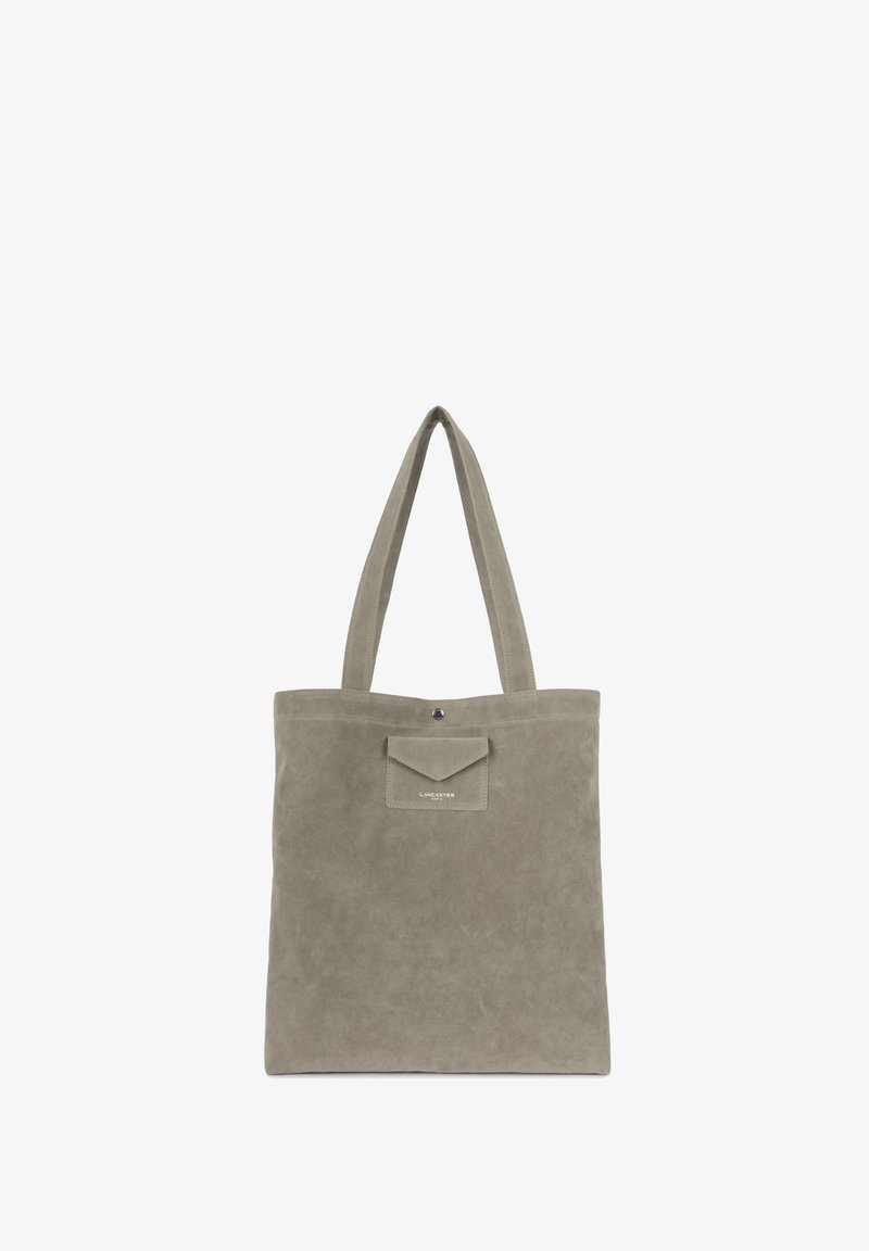 Sac fourre-tout en suède gris avec deux poignées, comportant une poche avant et une fermeture à pression. Texture douce et design minimaliste.
