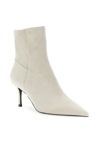 Bottine en daim beige avec un bout pointu et un talon slim de hauteur moyenne, au design épuré avec un minimum de détails de couture.
