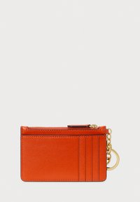 Πορτοφόλι κάρτας από πορτοκαλί δέρμα με τσέπη με φερμουάρ, τέσσερις θήκες για κάρτες και αποσπώμενο μπρελόκ. Απαλή υφή με μινιμαλιστικό σχέδιο.