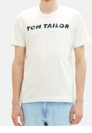 Bomulds-t-shirt i lys beige med korte ærmer. Har fed sort tekst "TOM TAILOR" og en blå accent, rund halsudskæring.