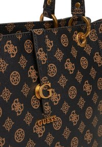 Borsa nera con texture e hardware dorato, caratterizzata da un motivo a logo marrone ripetuto e un accento con monogramma "G" dorato sulla parte anteriore.