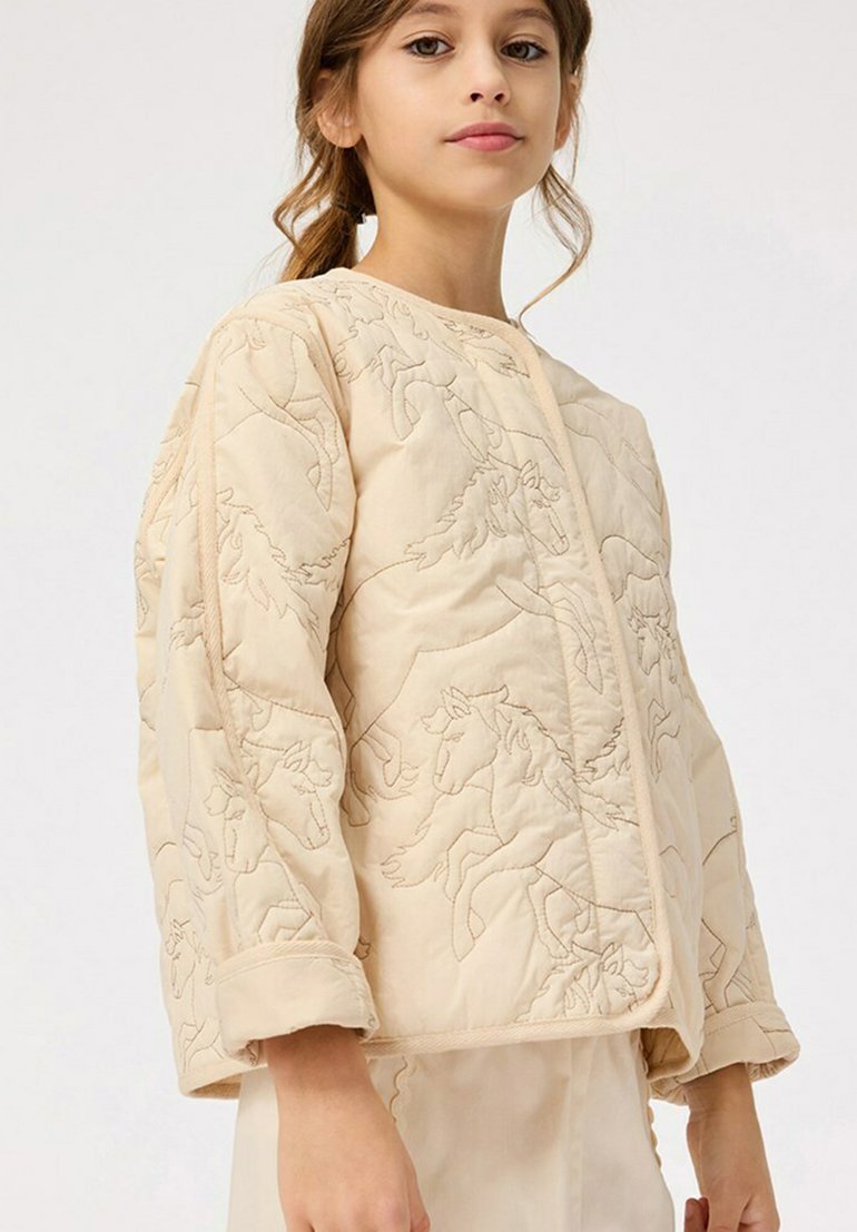 Quiltad beige jacka med ett broderat hästmönster, rund hals och manschetterade ärmar för en texturerad finish och strukturerad design.