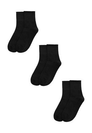 Tres pares de calcetines tobilleros negros lisos dispuestos sobre un fondo blanco.