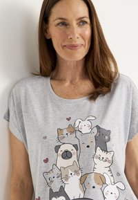 Grå t-shirt med kort ärm som har en färgglad grafik av tecknade djur, inklusive katter och en hund, med hjärtan i designen.