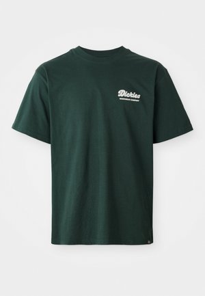 Groene katoenen T-shirt met een ronde hals, korte mouwen en een wit logo op de bovenste linkerkant. Lichtjes ontspannen pasvorm en een zachte textuur.