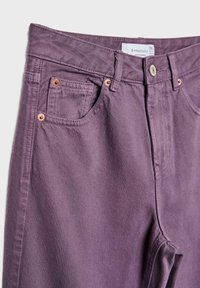 Jean en denim violet avec poches avant, rivets en cuivre et une étiquette de marque blanche visible à l'intérieur de la ceinture, taille 36.
