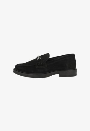 Black suede slip-on shoe with a rounded toe, flat sole, and decorative silver hardware accent on the front. Smooth texture and classic design.