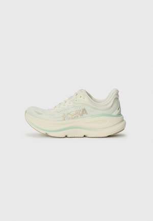 Light green running shoe with a mesh upper, padded collar, and a cushioned midsole. Features HOKA branding in metallic gold on the side.