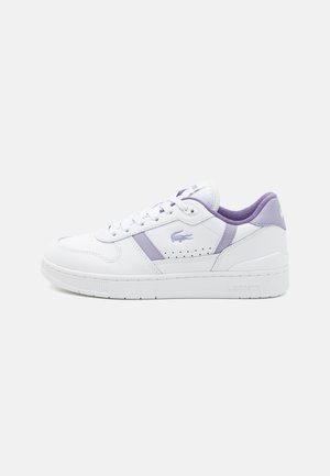 Basket en cuir blanc avec des accents violets, présentant un bout rond, des détails perforés et des lacets plats. Logo Lacoste sur le côté.