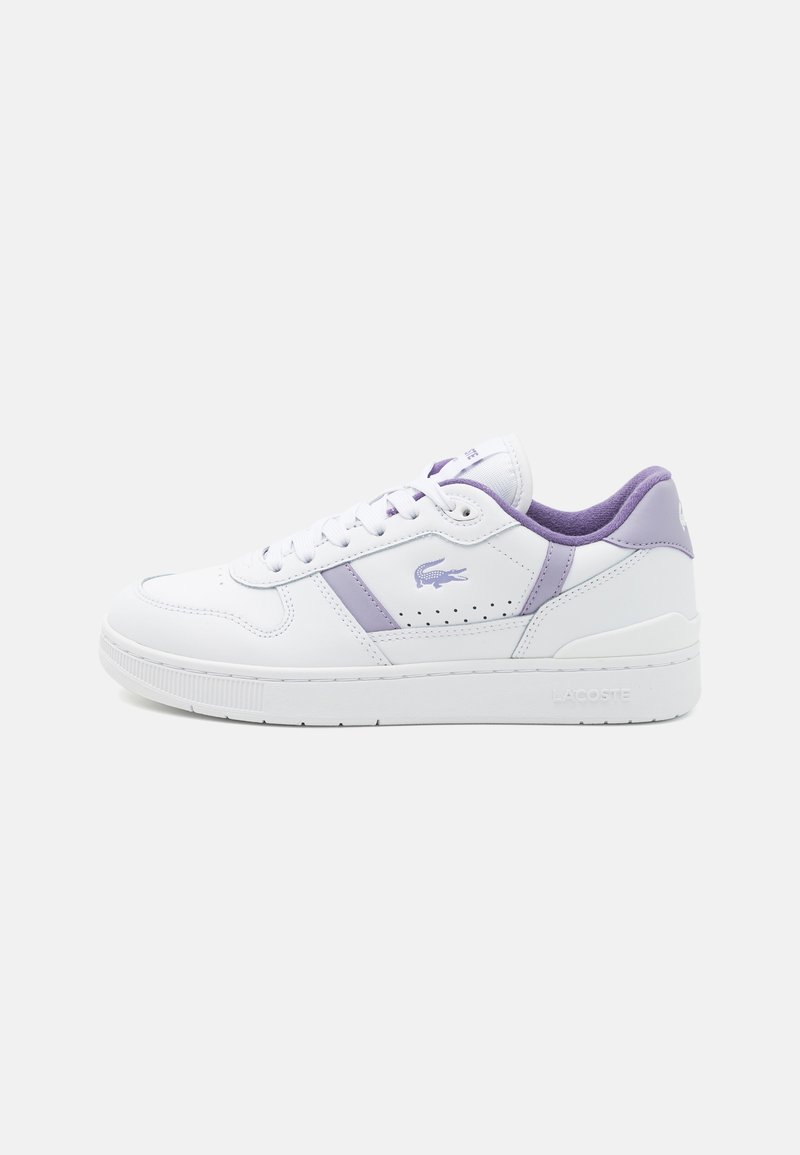 Sneaker bianca in pelle con accenti viola, caratterizzata da una punta rotonda, dettagli perforati e lacci piatti. Logo Lacoste sul lato.